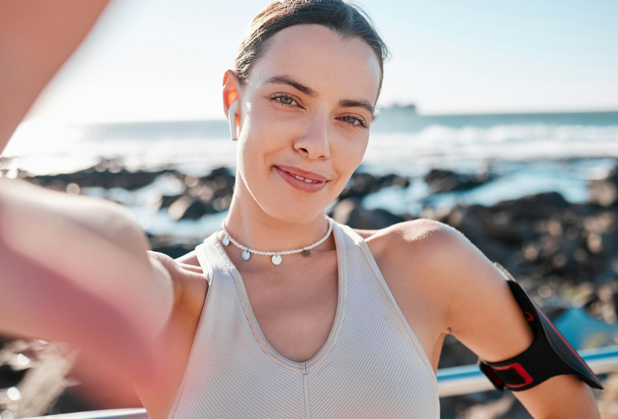 Fitness, woman and portrait smile for selfie, vlog or profile picture by beach for running exercise